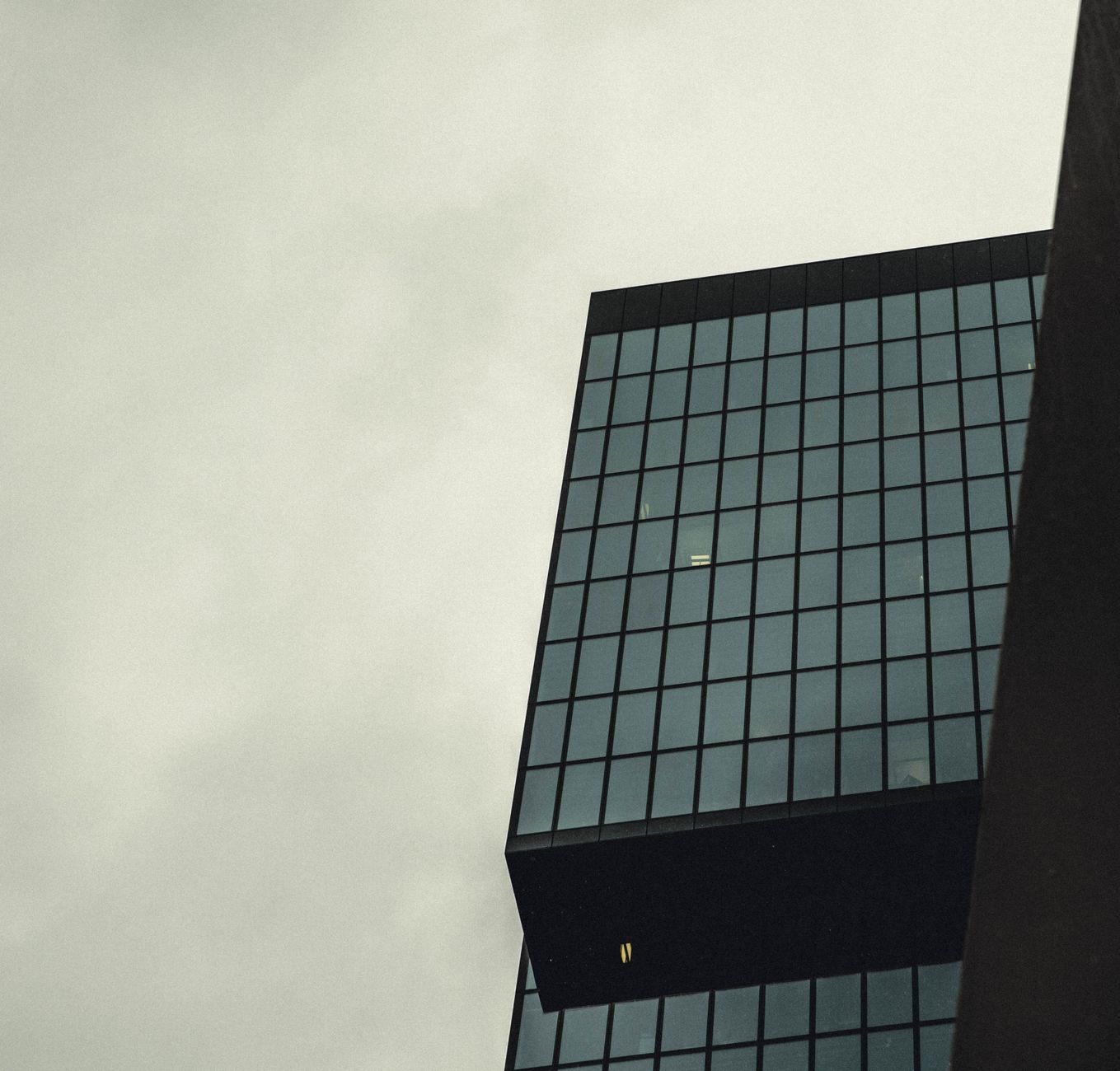 Glass office building against an overcast sky